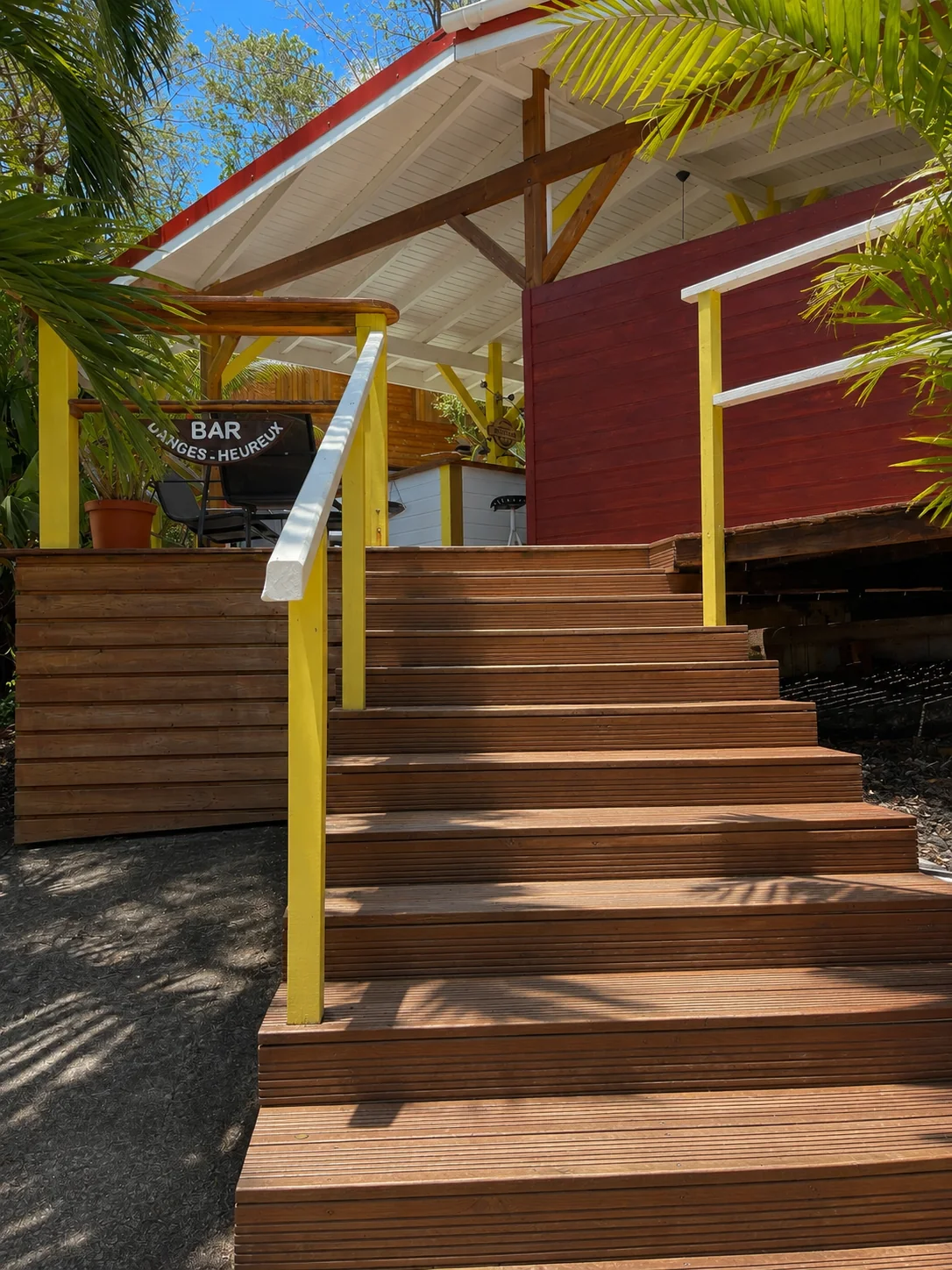 Entrée du bar : escalier en bois menant à la terrasse commune