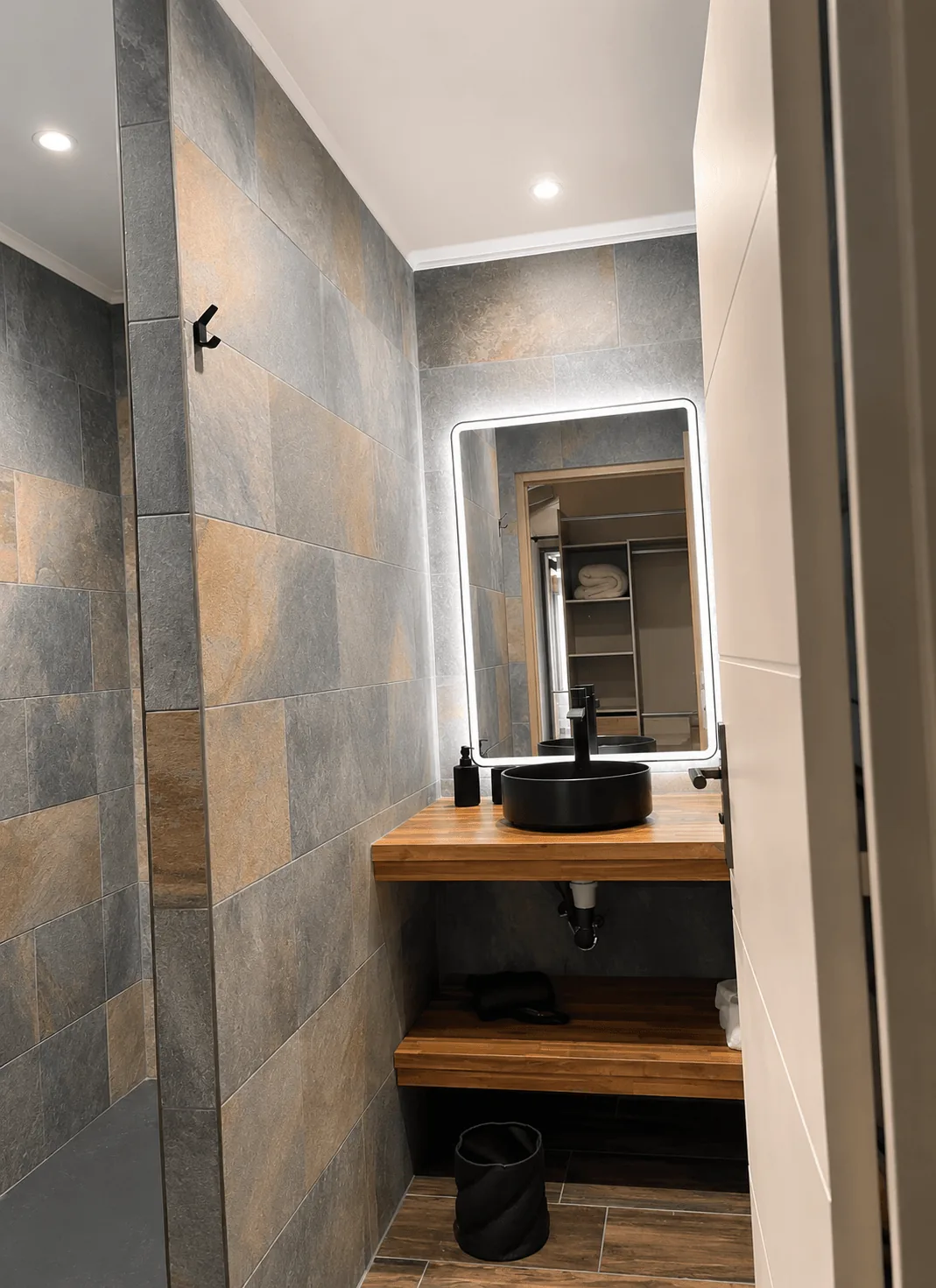 Salle de bain rénovée avec douche italienne, vasque noire et miroir LED, Appartement Colibri à Bouillante